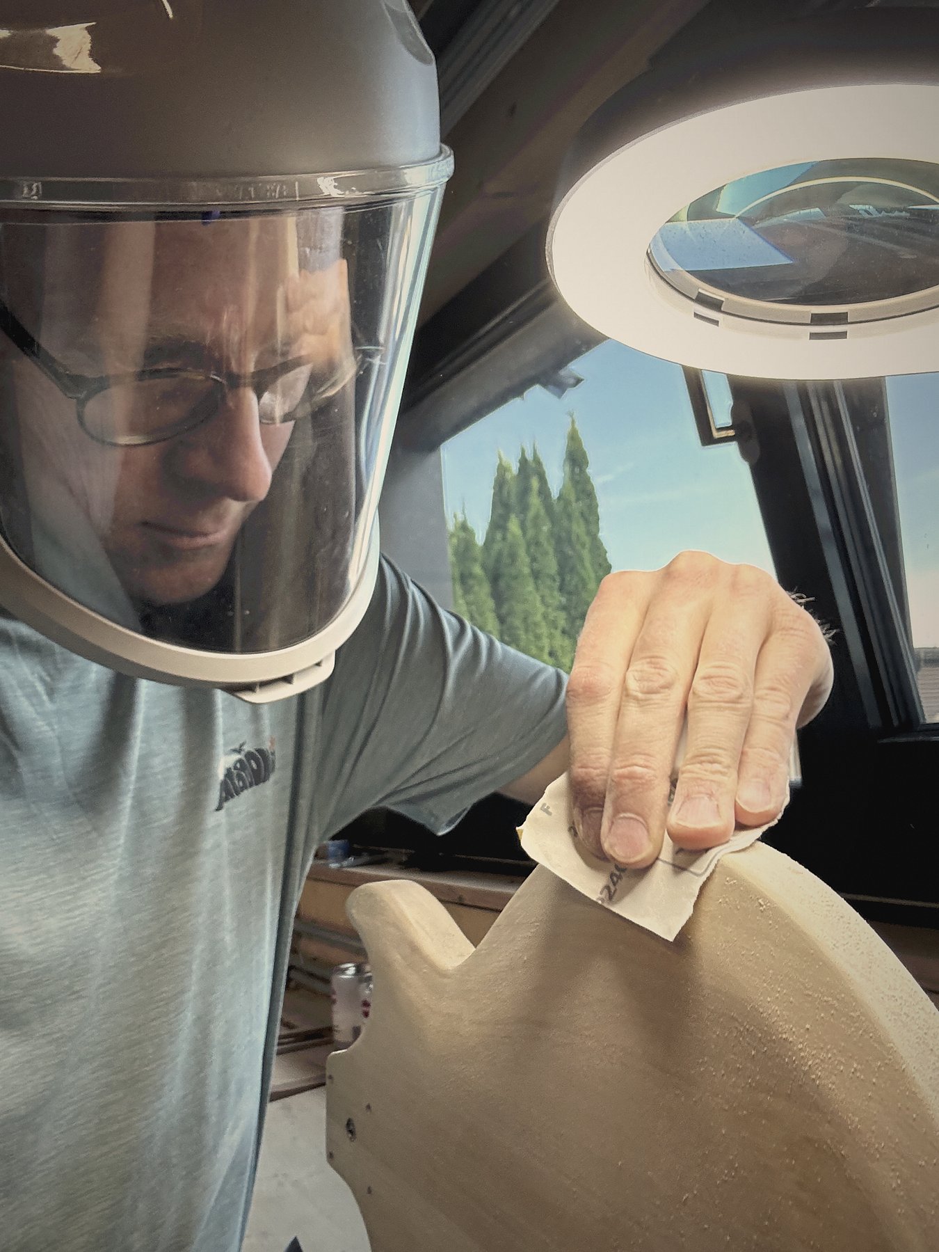 At the workbench, full-face respirator on, light low